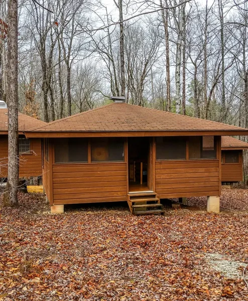 a wood cabin with screened-in windows