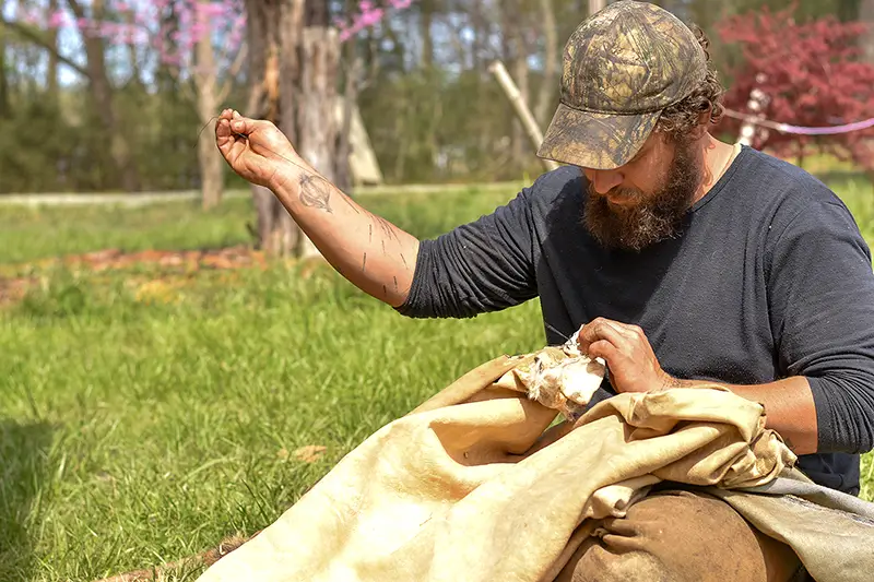 Matt Henson sewing a hide