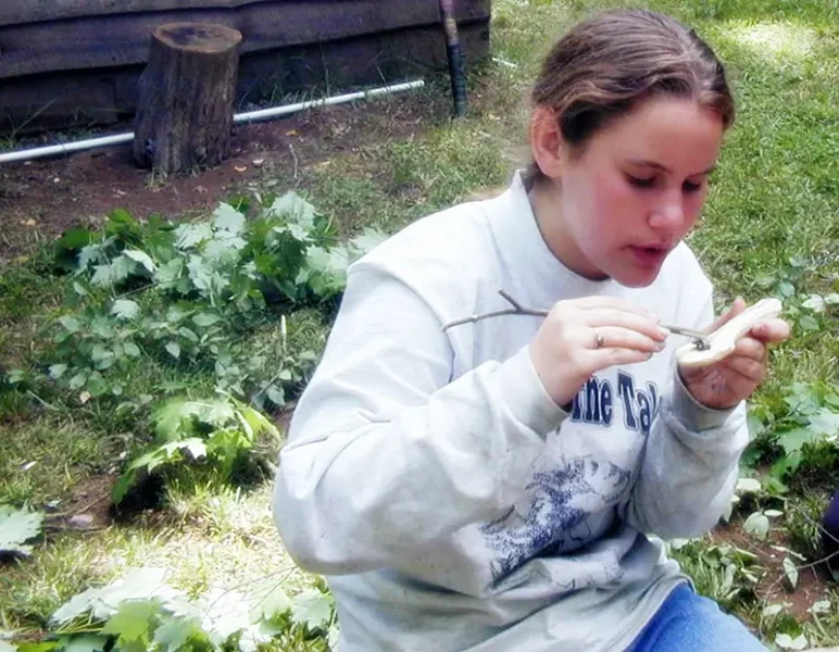 girl carving a wooden spoon