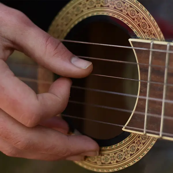 Nightly Music hand strumming a guitar