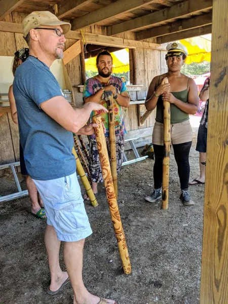 people holding didgeridoos