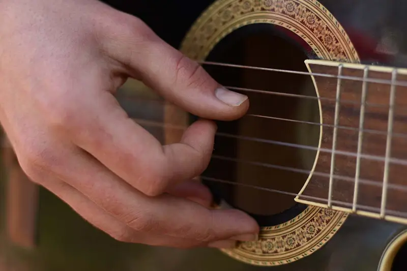a hand picking a guitar